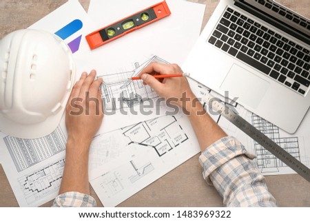 Male architect working at table, top view