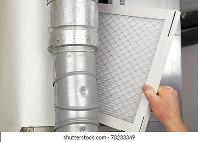 Male Arm And Hand Replacing Disposable Air Filter In Residential Air Furnace.