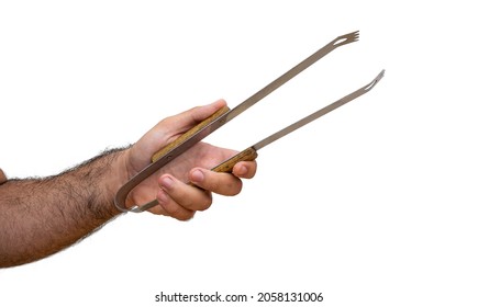 male arm outstretched with barbecue tongs isolated on white