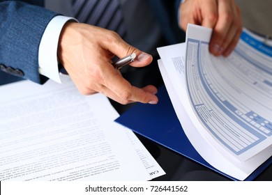 Male arm in suit offer insurance form clipped to pad and silver pen to sign closeup. Strike a bargain, driver money loss prevention, secure road trip, harmless drive idea, owner protective concept