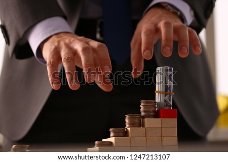 Male arm in suit reach for money closeup. Participant in financial pyramid did not have time to collect his money at moment when everything collapsed concept.
