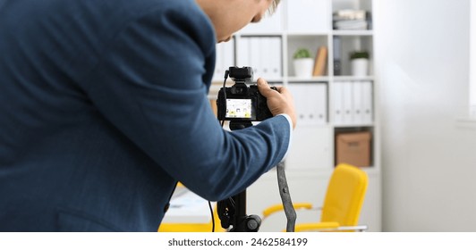 Male arms in suit mount camcorder to tripod making promo videoblog or photo session in office closeup. Vlogger adjust set up and check image quality to show job offer promotion selfie information - Powered by Shutterstock