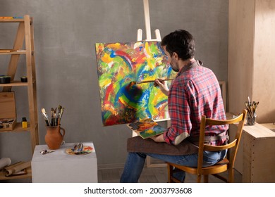 Male artist working on painting. Man artist painter in creative studio as art concept