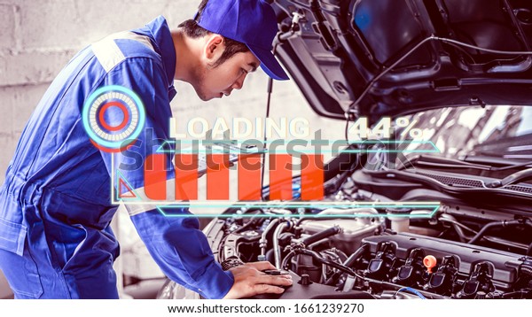 male Asian car mechanic using a computer\
laptop to diagnosing and checking up on car engines parts for\
fixing and repair, Loading energy car\
