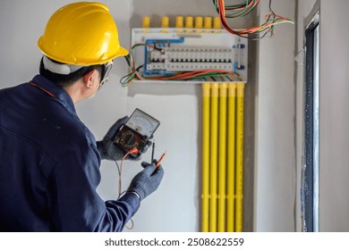 A male Asian electrician or electrician Install and test outlets and switches for electricity in houses and buildings.