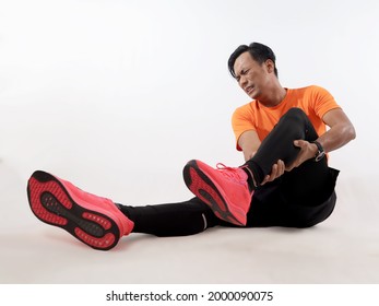 Male Asian runner having lower leg pain, calf muscle cramp because of not doing warm up before run exercise. High key studio shot, sport injury concept