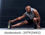 Male athlete, exercise and stretching leg with hand for sports, workout and fitness in gym. Healthy man, challenge and cardio routine for wellness, muscle and strength training for mental wellbeing