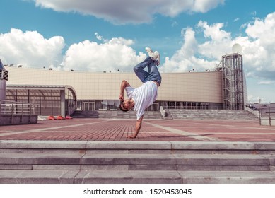 Male Athlete, Guy Dancer Summer City. Standing One Arm Jump. Fashionable Modern Break Dance Style Fast, Fitness Sport Hip Hop Motion. Urban Culture Street Dance. Acrobatic Exercises. In T-shirt Jeans