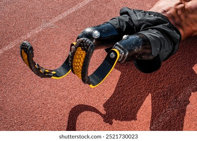 Male athlete with prosthetic legs on a brick colored running track. Prosthetic legs in action. Athletic prosthetic legs for running. Male athlete showcasing prosthetic legs. Photo of a sport man. - Powered by Shutterstock