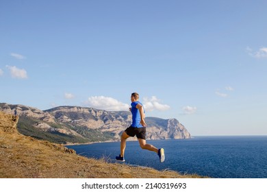 Male Athlete Running Uphill Trail On Sky And Sea Background