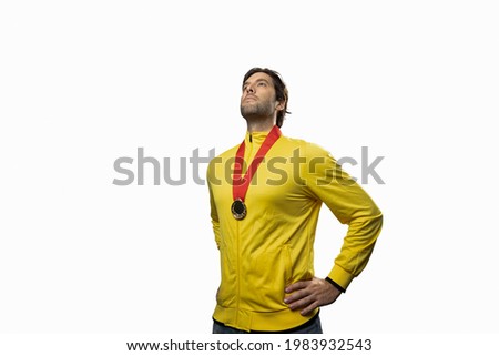 male athlete smiling after winning a gold medal in a white background. Sportsman with medal celebrating his victory.