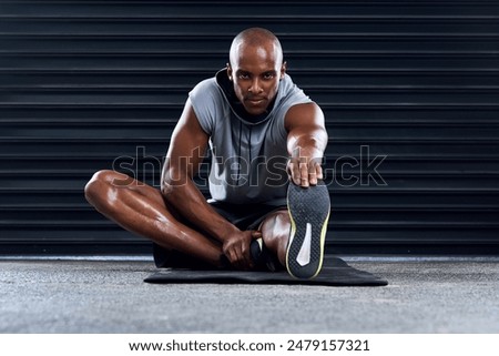 Male athlete, stretching and leg in portrait, exercise for sports in workout, fitness at gym. Healthy, African man and challenge in cool down routine for wellness, muscle for strength training