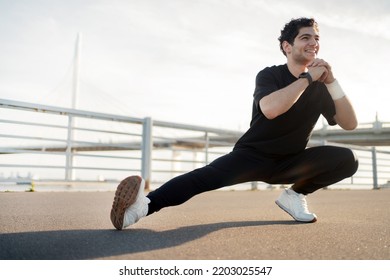 Male Athlete Training In The City In Sportswear. Uses A Fitness Watch.