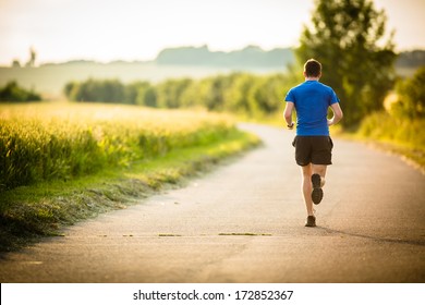 Male athlete/runner running on road - jog workout well-being concept - Powered by Shutterstock