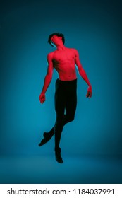 The Male Athletic Ballet Dancer Performing Dance On Vivid Blue Background. Studio Shot. Modern Ballet, Contemporary Concept. Fit Young Man. Caucasian Model