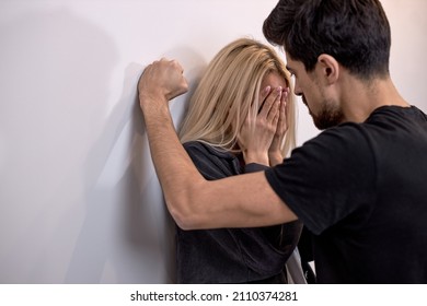 male attacks woman, domestic violence. Drunk husband beats wife. An aggressive man hits young wife, female, crying. Pinned to the wall and scared. family domestic domination couple