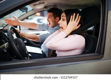 Male Auto Instructor Takes Exam In Young Woman. Screaming And Yelling. Looking Forward. Woman Drive Car But Doesn't Hold Hands On Steering Wheel. Stress And Discomfort.