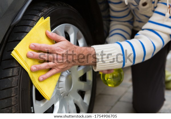 Male auto\
service staff cleaning a tyre with\
duster