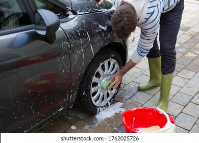 Male auto service staff washing a car tyre with sponge - Shutterstock ID 1762025726