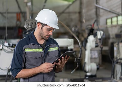 Male automation engineer using tablet control robot arm welding machine in an industrial factory.Artificial intelligence - Powered by Shutterstock