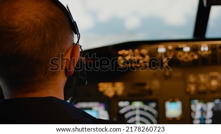 Male aviator using handle and windscreen in cockpit to fly airplane, throttling power engine to takeoff. Commanding aircrew and using control panel dashboard. Close up.