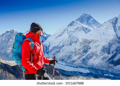 Male backpacker enjoying the view on mountain walk in Himalayas. Face to face with mount Everest, Earth's highest mountain. Travel sport lifestyle concept