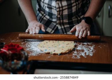 Male baker preparing dough with a rolling pin on a wooden surface. - Powered by Shutterstock