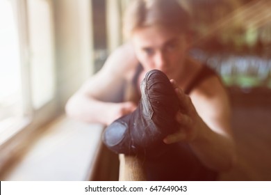 Male ballet dancer stretching at ballet barre, close-up of foot. Selective focus. - Powered by Shutterstock