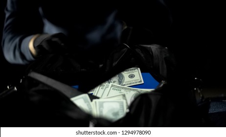 Male bandit looking at money bag stolen from city bank, robbery, criminality - Shutterstock ID 1294978090