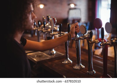 Male Bar Tender At Bar Counter In Pub