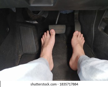Male bare feet on the brake and accelerator pedals in a car - Shutterstock ID 1835717884