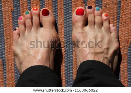 male barfoot feet painted with colored nail varnish