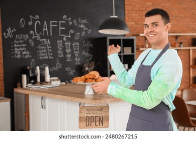 Male barista with OPEN sign in coffee shop - Powered by Shutterstock