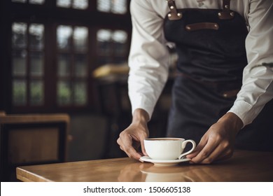 Male Barista preparing coffee for customer in coffee shop. Cafe owner serving a client at the coffee shop. - Powered by Shutterstock