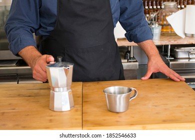 Male Barista Preparing Fresh Espresso In Coffee Maker For Customer In A Fancy Coffee Shop. Cafe Owner Serving A Client At The Coffee Shop.