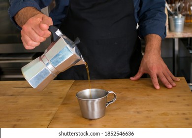 Male Barista Preparing Fresh Espresso In Coffee Maker For Customer In A Fancy Coffee Shop. Cafe Owner Serving A Client At The Coffee Shop.