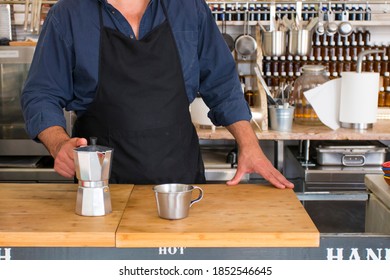 Male Barista Preparing Fresh Espresso In Coffee Maker For Customer In A Fancy Coffee Shop. Cafe Owner Serving A Client At The Coffee Shop.