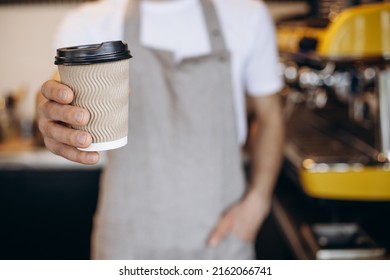 Male Barista Serving Coffee In Cardboard Cups