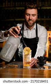 Male Bartender Skilfully Adds Carbonated Liquid From Siphon To Transparent Glass With Cold Freshness Cocktail On Bar Counter