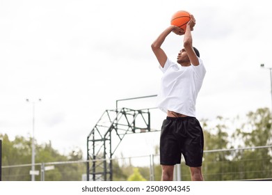 Male basketball player throwing the ball to the basket - Powered by Shutterstock