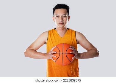 Male basketball player wearing sportswear holding basketball on white background with a determined face.
 - Powered by Shutterstock