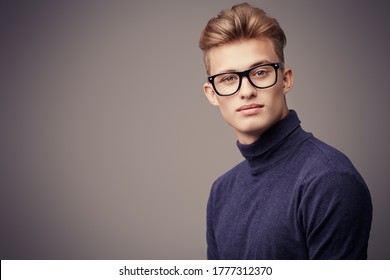 Male Beauty. Portrait Of A Handsome Young Man With Blond Hair Wearing Glasses And Look At Camera. Optics For Men.