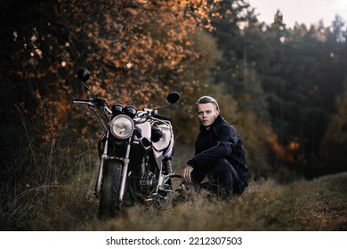 Male Biker Motorcyclist With Retro Motorcycle In Autumn Forest.