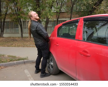 A Male Biker Pisses In The Gas Tank Of A Car.  Bad Fueling Concept Or Bikers Attitude Towards Car Drivers