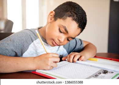 A Male Black Child Doing Homework At Home