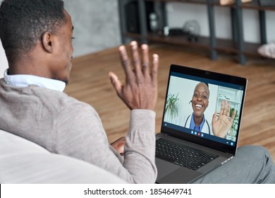 Male Black Patient Talking On Conference Video Call To Female African Doctor. Virtual Therapist Consulting Young Man During Online Appointment On Laptop At Home. Telemedicine Chat, Telehealth Meeting