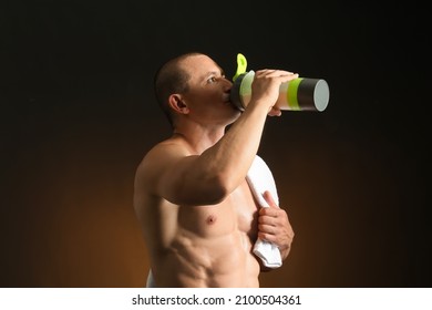 Male Bodybuilder Drinking Protein Shake On Dark Background