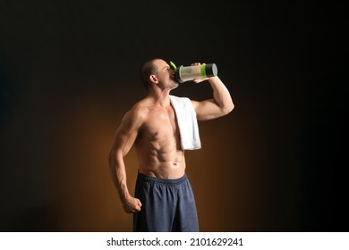 Male Bodybuilder Drinking Protein Shake On Dark Background