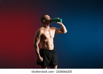 Male Bodybuilder Drinking Protein Shake On Dark Background