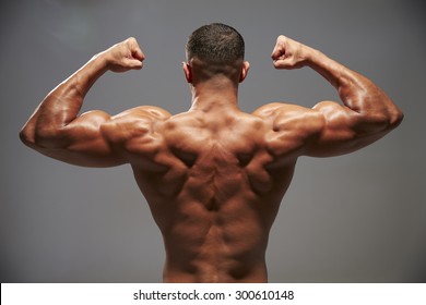 Male bodybuilder flexing his biceps, back view